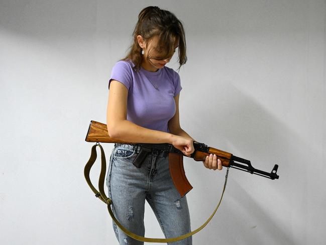 A schoolgirl attends a lesson to learn how to handle a Kalashnikov AK47 rifle, equipped with an electronic sight, during a lesson at the military-patriotic center in Lviv, Ukraine. Picture: Yuriy Dyachyshyn/AFP 