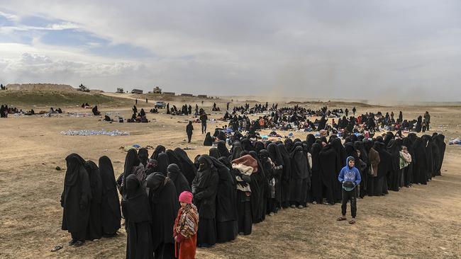 Civilians evacuated from the Islamic State (IS) group's embattled holdout of Baghouz wait at a screening area held by the US-backed Kurdish-led Syrian Democratic Forces (SDF), in the eastern Syrian province of Deir Ezzor, on March 5, 2019. - Kurdish-led forces launched a final assault Friday on the last pocket held by the Islamic State group in eastern Syria, their spokesman said. The "operation to clear the last remaining pocket of ISIS has just started", Mustefa Bali, the spokesman of the US-backed Syrian Democratic Forces, said in a statement using an acronym for the jihadist group. (Photo by Bulent KILIC / AFP)