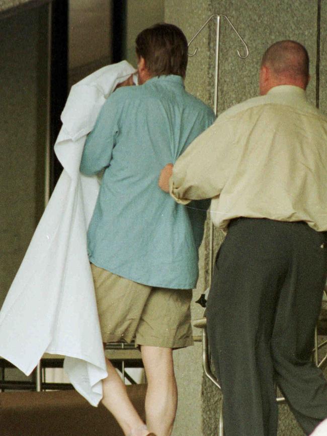 Police escort Neil Morrison from the Gold Coast Hospital in 1999.