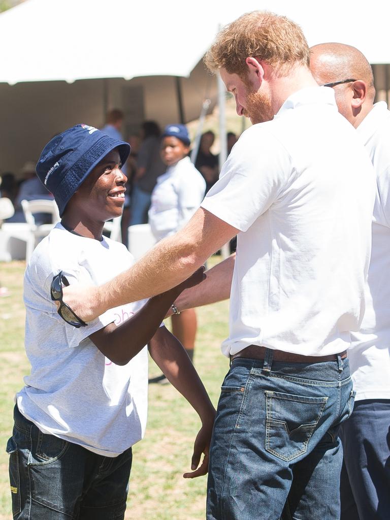 Prince Harry hugs ‘Mutsu’ a young boy he made friends with on his first visit to Lesotho at the Official Opening of the new Mamohato Children’s Centre on November 26, 2015 in Maseru, Lesotho. Picture: Getty