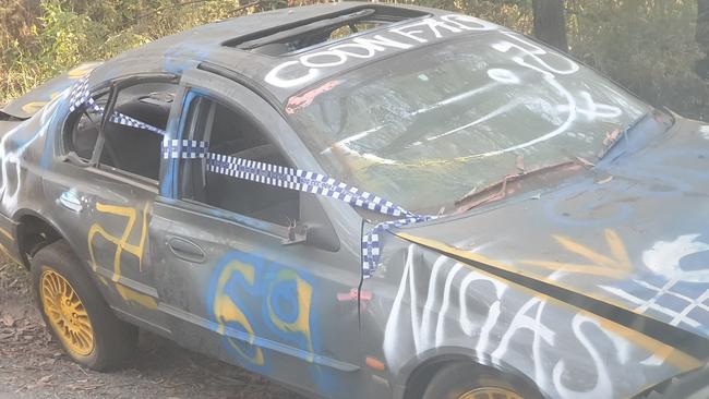 An abandoned car, covered in racist words and swastikas, has been left by the side of a Yellingbo road for a week.