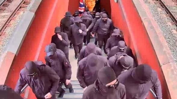 The group of men can be seen boarding a train dressed entirely in black, one at the back seen here carrying an Australian flag. Picture: Supplied