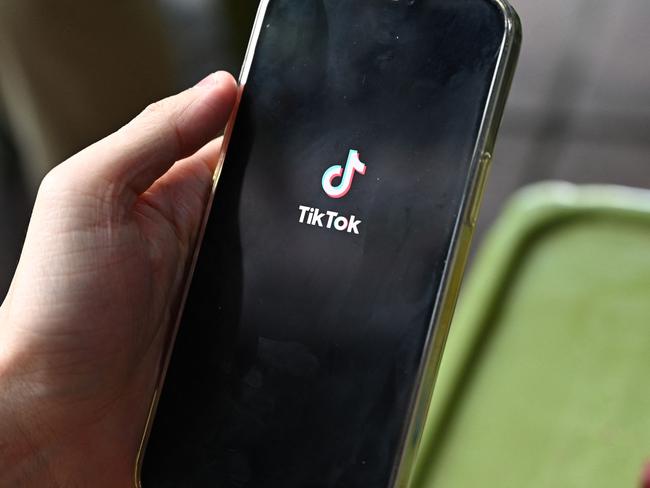 (FILES) The logo of the social media platform TikTok is displayed on a mobile phone in Hanoi on October 6, 2023. New Vietnamese internet rules requiring Facebook and TikTok to verify user identities and hand over data to authorities came into force on December 25, in what critics say is the latest attack on freedom of expression. (Photo by Nhac NGUYEN / AFP)