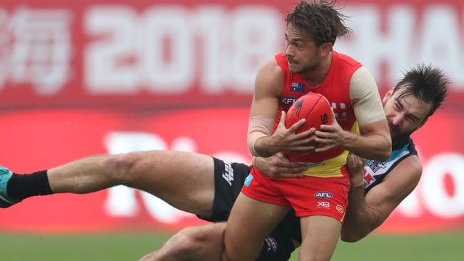 Charlie Dixon tries to bring down Sun Jarrod Harbrow. Picture: Sean Garnsworthy/AFL Media/Getty Images