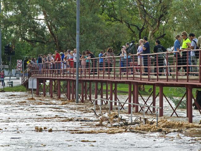 Locals gather at the Wills Terrace Causeway to take in the power of the Todd River flow. PHOTO: Barry Skipsey