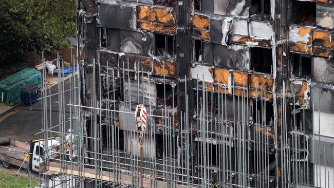 Scaffolding is seen with coverings at the base of the burned-out-shell of Grenfell Tower. / AFP PHOTO / CHRIS J RATCLIFFE