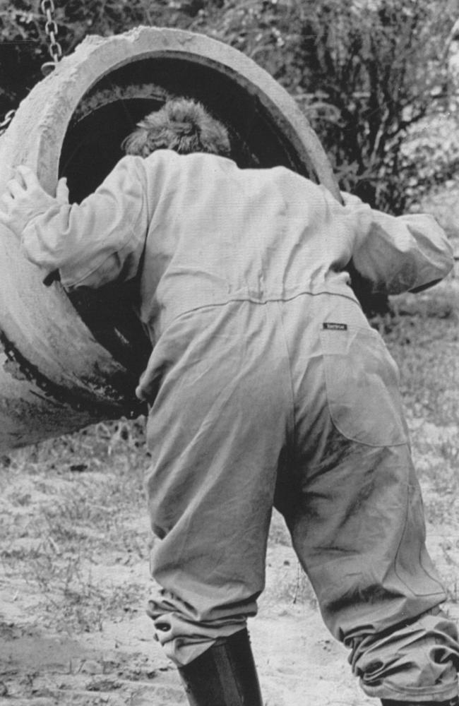 An officer searches a drain after bones and underwear were found near the Birnies’ home in Fremantle.