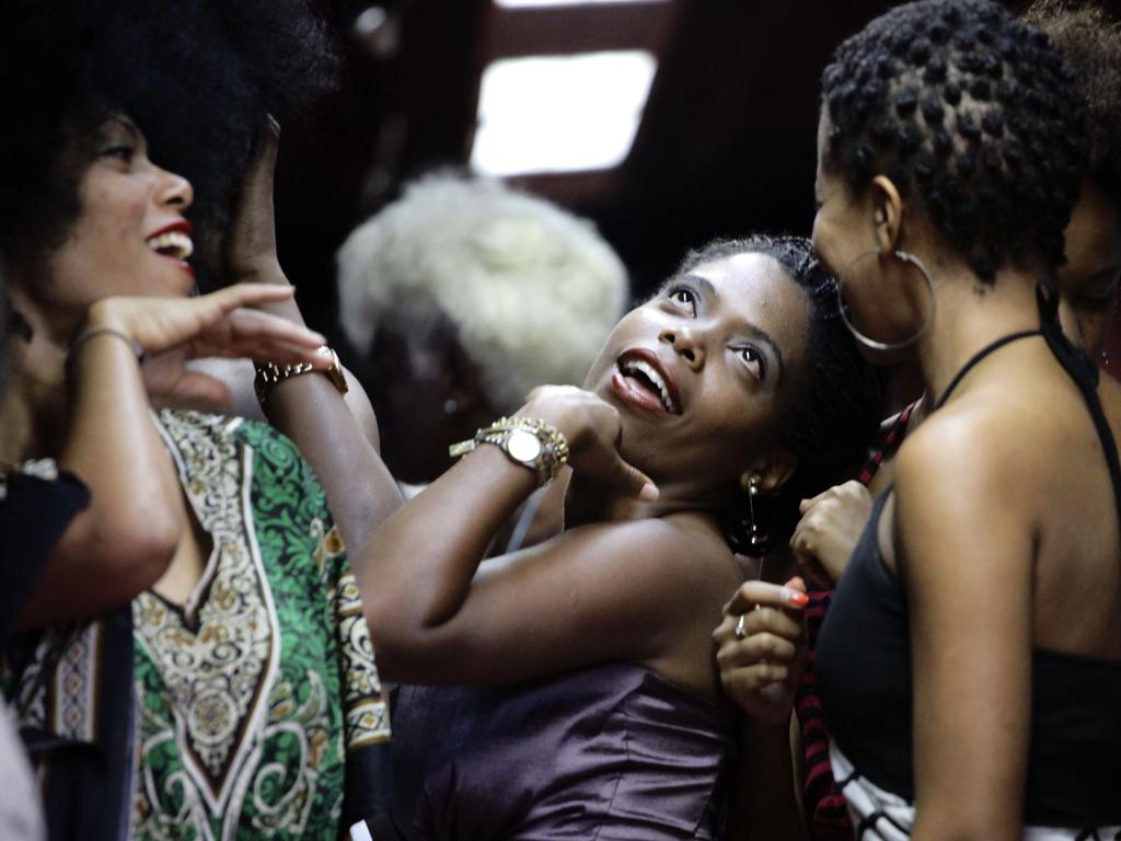 Contestants joke as they wait to walk on the catwalk during an Afro hair contest in Havana on June 13, 2015. Picture: AAP