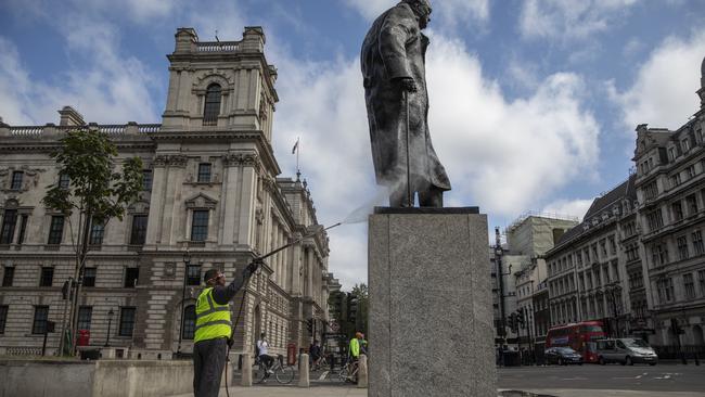 A worker cleans the Churchill statue in Parliament Square that had been spray painted with the words 'was a racist'. Picture: Dan Kitwood/Getty Images