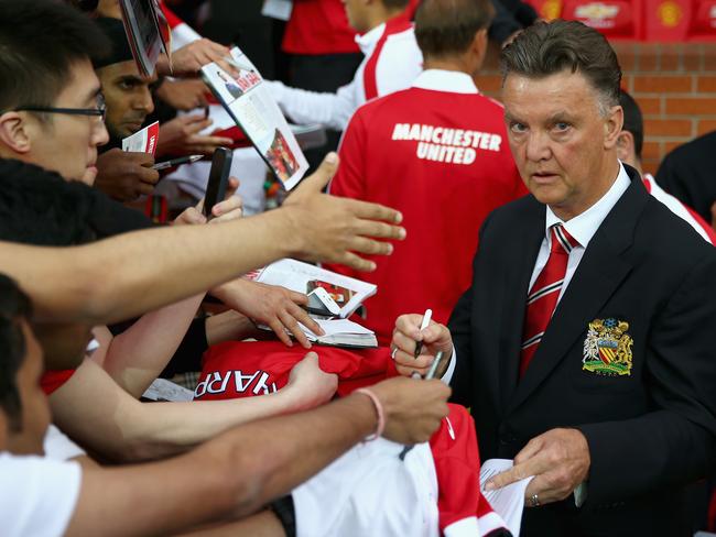 MANCHESTER, ENGLAND - AUGUST 12: Manchester United manager Louis Van Gaal signs autographs as he makes his home debut during the Pre Season Friendly match between Manchester United and Valencia at Old Trafford on August 12, 2014 in Manchester, England. (Photo by Clive Brunskill/Getty Images)