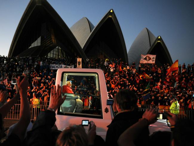 Pope Benedict XVI waves to the huge crowds lining the streets of Sydney as his motorcade passes the Sydney Opera House in 2008. Picture: Dean Lewis/AAP