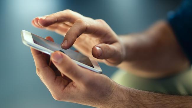 Generic Male hands typing on smartphone. Picture: Istock