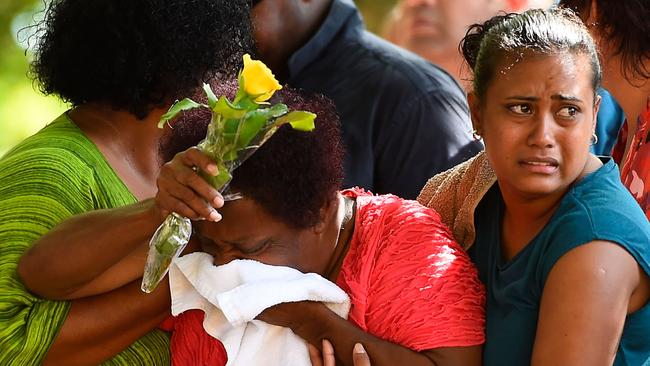 CAIRNS, AUSTRALIA - DECEMBER 21: Family members mourn at the scene of a memorial which is located in the park next the home of a multiple stabbing in the suburb of Manoora on December 21, 2014 in Cairns, Australia. Eight children have been found dead and a 37-year-old woman is in hospital with chest injuries at a home in North Queensland. The children, aged 18 months to 14 years have reportedly been stabbed and the woman has been arrested for murder. (Photo by Ian Hitchcock/Getty Images)