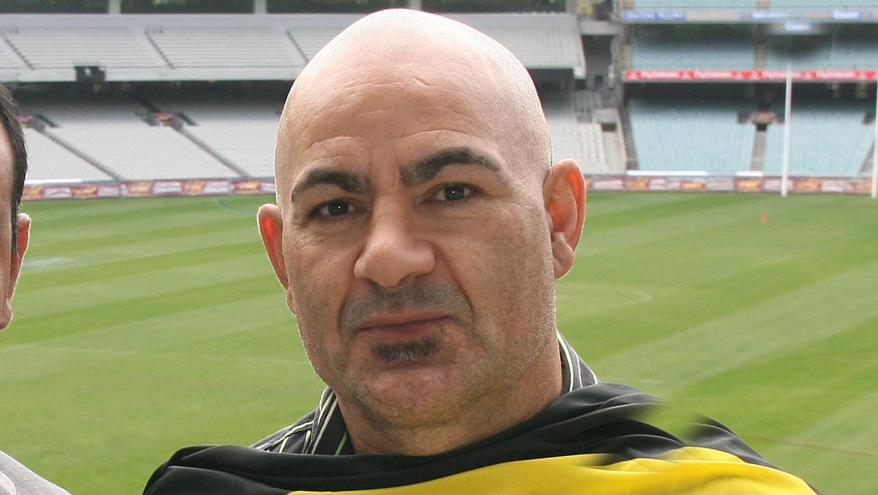 Former AFL footballers Michael Long (Essendon) and Phil Egan (Richmond) at the MCG promoting the AFL indigenous round.Long has the Torres Strait Islands flag and Egan has the Aboriginal flag.