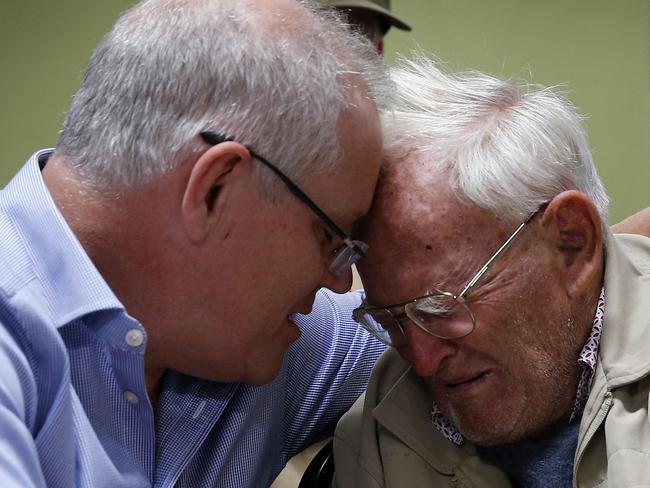 Prime Minister Scott Morrison is seen comforting 85 year old Owen Whalan of Half Chain road in Koorainghat who has been evacuated from his home during a visit to Club Taree Evacuation Centre in Taree, New South Wales, Sunday, November 10, 2019. (AAP Image/Darren Pateman) NO ARCHIVING