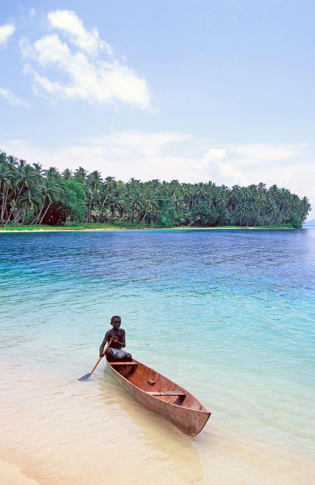 Solomon Islands. Sagheraghi Beach on Gizo Island, local boy in canoe. Photo - Alamy Escape (June 2024)