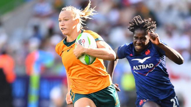 Australia's Maddison Levi (L) runs past France's Hawa Tounkara (R) to score a try during the third place play-off of the HSBC World Rugby Sevens Series women's rugby match between France and Australia at the Cape Town stadium in Cape Town on December 8, 2024. (Photo by Rodger Bosch / AFP)