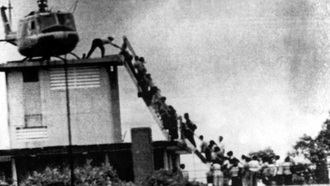 People climb to a helicopter during the evacuation of Saigon.