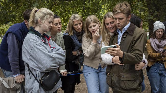 A group watches the funeral on a phone along The Mall near Buckingham Palace. Picture: Getty Images