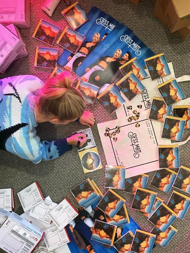 Jess and Matt signing copies of their CD for fan pre-orders. Pic: Supplied