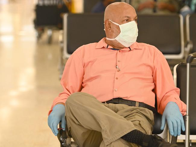 A passenger waits in the arrival hall at Sydney’s Airport. Picture: AFP