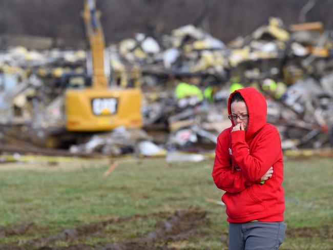 A woman walks away from what is left of the Mayfield Consumer Products Candle Factory as emergency workers comb the rubble after it was destroyed by a tornado in Mayfield, Kentucky. Picture: John Amis / AFP