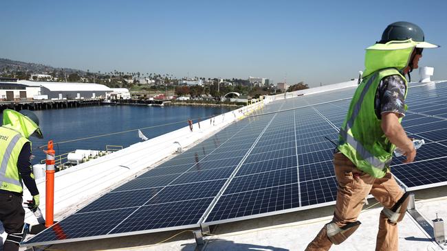 Workers gather as they install solar panels at the Port of Los Angeles. Biden’s IRA Act is dramatically reshaping green investment. Picture: Getty Images