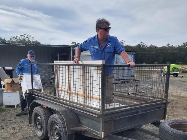 Ex-servicemen and ex-servicewomen volunteering with Disaster Relief Australia help with the clean-up in Taree.