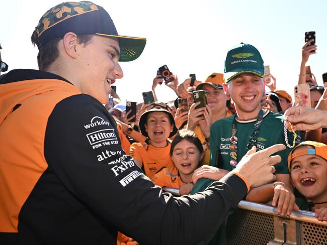 MELBOURNE, AUSTRALIA - MARCH 22: Oscar Piastri of Australia and McLaren signs autographs at the fan stage prior to practice ahead of the F1 Grand Prix of Australia at Albert Park Circuit on March 22, 2024 in Melbourne, Australia. (Photo by Quinn Rooney - Formula 1/Formula 1 via Getty Images)