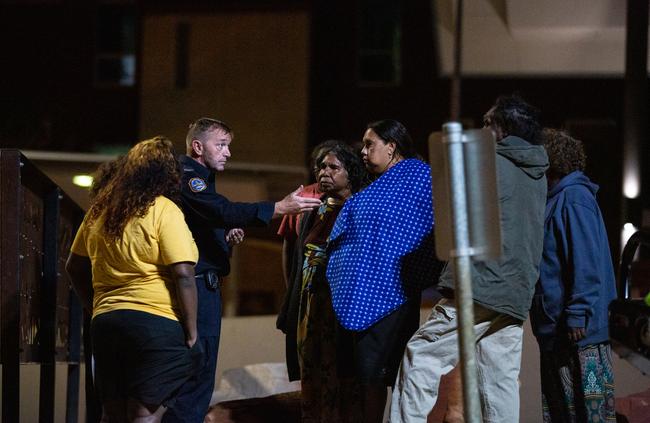 Mr Walker’s family question a police officer at the Alice Springs Hospital, hoping to find out if he is still alive. Picture: Emma Murray