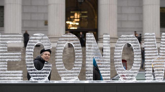 A pedestrian walks past the melting ice sculpture called "Main Street Meltdown". Picture: AFP