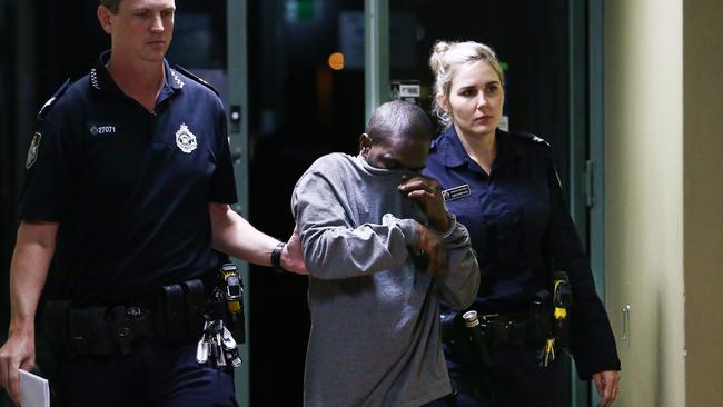 Cairns police officers escort Kowanyama man Lenfred Leighwayne Tommy through Cairns Airport. Picture: Brendan Radke