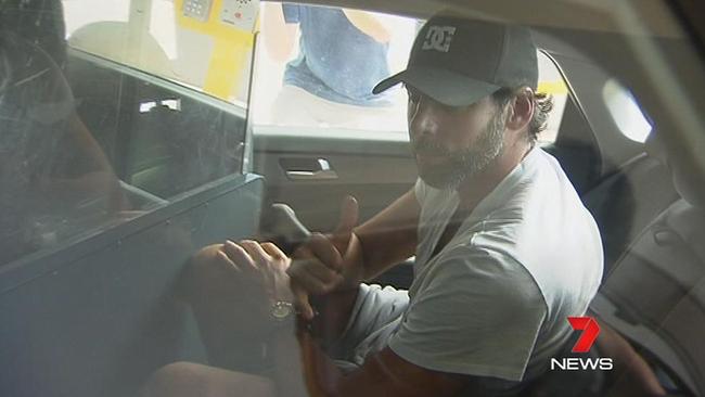 Grant Hackett is seen being taken into a Gold Coast police station following his arrest. PIC: Seven News