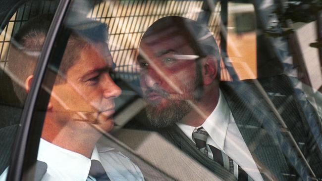 SA convicted murderer Michael Barry Fyfe tries to kiss a guard on the cheek while being driven from court to Yatala Labor Prison in 2000.