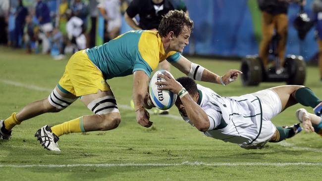 Australia's Con Foley, left, defends a try attempt by South Africa's Juan de Jongh.