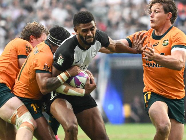 Fiji's Ponipate Loganimasi (C) fends off Australiaâs Michael Hooper (R) in their Pool A match at the 2024 Rugby Sevens Hong Kong tournament at the Hong Kong stadium on April 5, 2024. (Photo by Peter PARKS / AFP)