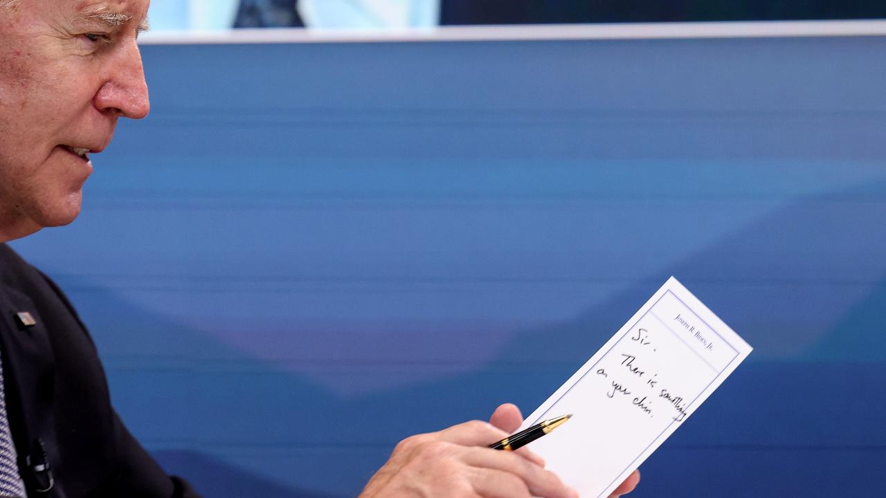 Joe Biden holds up a note saying "Sir, there is something on your chin" during a virtual meeting with Kamala Harris and US Governors. Picture: Anna Moneymaker/Getty Images/AFP