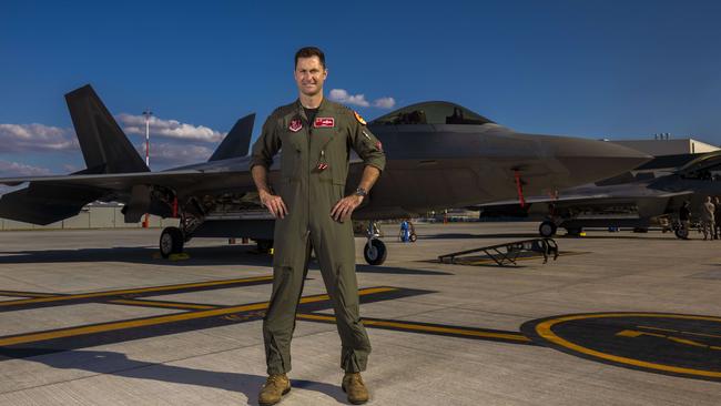 Flight Lieutenant Paul Anderton in front of a F-22 fighter jet at Amberley base in Queensland. Picture: Glenn Hunt