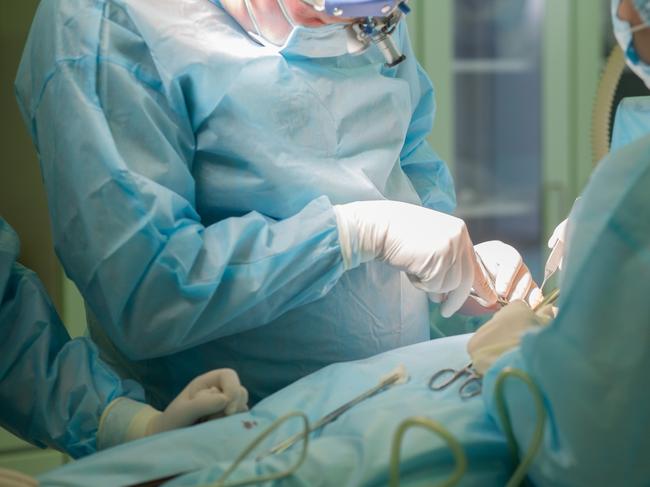 Surgical team performing cosmetic surgery in hospital operating room. Breast augmentation at medical clinic. Breast enlargement, enhancement. Mammaplasy . Picture: iStock