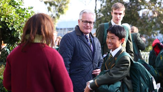 Michael Davies with parents and students outside the Kew campus of Trinity Grammar in Melbourne yesterday. Picture: Aaron Francis