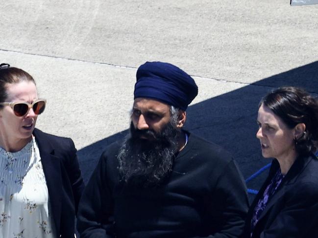 Queensland Police officers and detectives escort Rajwinder Singh from the government jet to a waiting police car at Cairns Airport after being extradited from New Delhi to Cairns via Melbourne. Picture: Brendan Radke