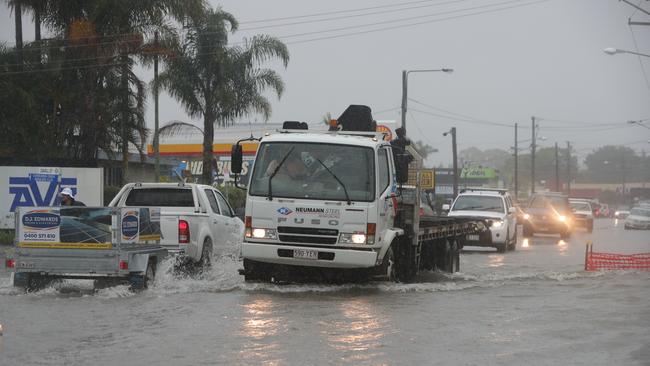 Major flooding in Currumbin Creek rd at Currumbin. Traffic sends waves through shops and factories. Picture Glenn Hampson