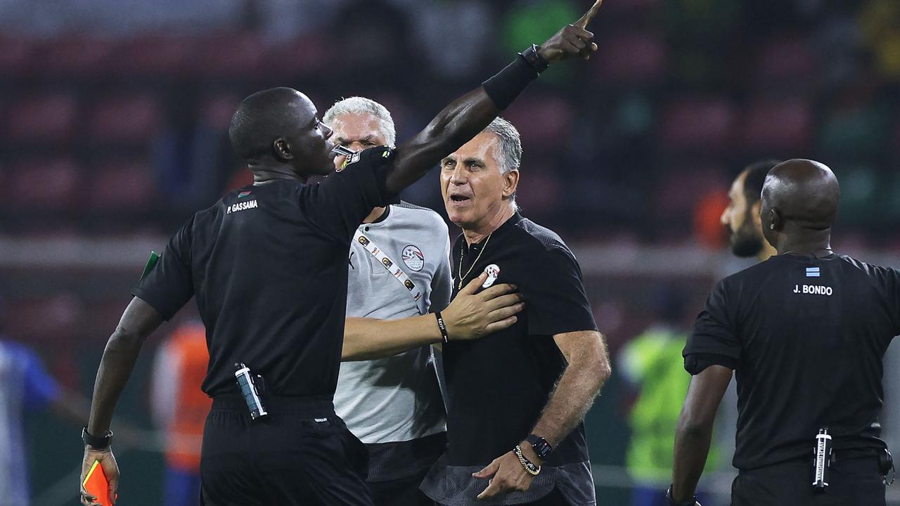 Gambian referee Bakary Gassama (L) gives a red card to Egypt's Portuguese head coach Carlos Queiroz (C) in a wild semi-final.