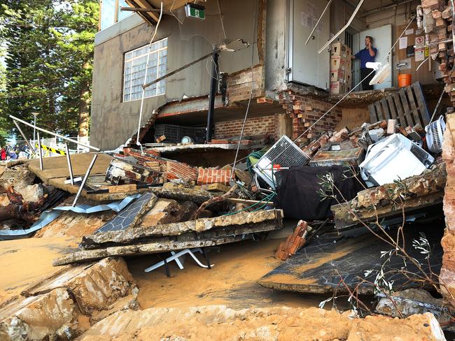 A man stands inside an area of The Beach Club severely damaged by heavy rain. Picture: AAP