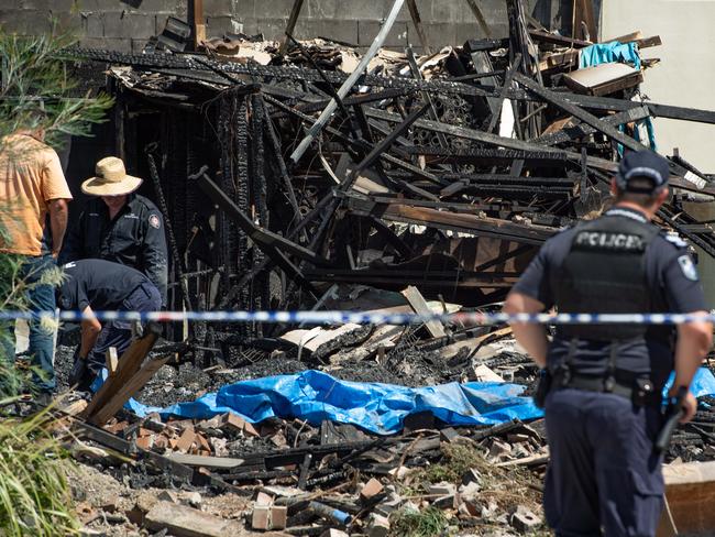 Investigators comb through the fire ruins by hand and with shovels on Monday. Picture: Brad Fleet