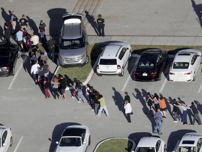Students are evacuated by police from Marjory Stoneman Douglas High School in Parkland, Florida. Picture: AP