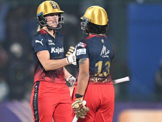 Royal Challengers Bangalore's Richa Ghosh (R) celebrates with Ellyse Perry after winning the Women's Premier League (WPL) Twenty20 cricket final match between Royal Challengers Bangalore and Delhi Capitals at the Arun Jaitley Stadium in New Delhi on March 17, 2024. (Photo by Sajjad HUSSAIN / AFP) / -- IMAGE RESTRICTED TO EDITORIAL USE - STRICTLY NO COMMERCIAL USE --