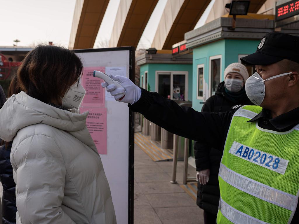 A security guard checks the temperature of a woman at the entrance of a park in Beijing. Picture: Nicolas Asfouri/AFP