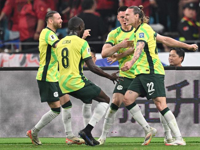 Australia's Jackson Irvine (R) celebrates with teammates after scoring a goal during the 2026 FIFA World Cup qualification football match between China and Australia at the Hangzhou Olympic Sports Center Stadium in Hangzhou, in China's eastern Zhejiang province on March 25, 2025. (Photo by Hector RETAMAL / AFP)