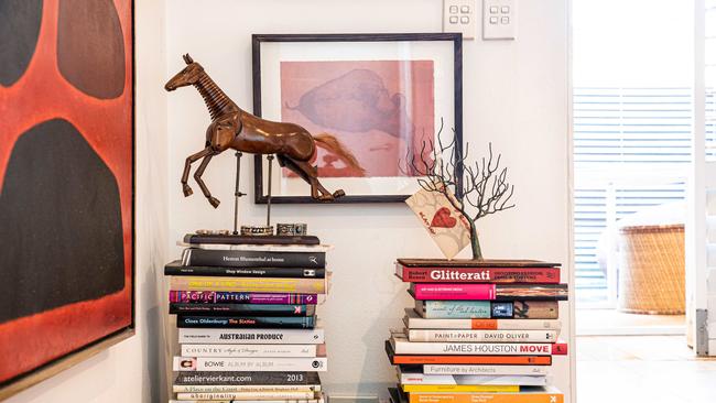 Kathy's favourite books and John Cobun Mataranka (large red painting on left side) Vintage wooden mechanical horse. Picture: Flavio Brancaleone